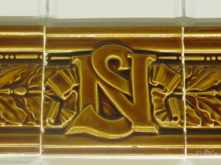 Nord-Sud monogram in the tiling surrounding a station name. By Tangopaso (Own work) [Public domain], via Wikimedia Commons
