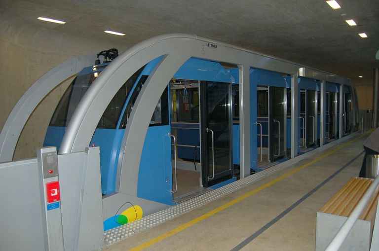 One of the Hungerburgbahn vehicles on level track at the underground station in Innsbruck. All the blue cabins are sitting in a line within the grey 'cage' which is what the wheels and cable are attached to. By Wolfgang Glock (Own work) [CC-BY-3.0], via Wikimedia Commons