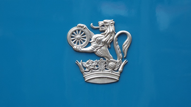 Cast aluminium version of the lion and wheel emblem. This is a modern reproduction on a locomotive restored to its original appearance. Photo by Steven Hughes [CC BY 2.0] via this flickr page