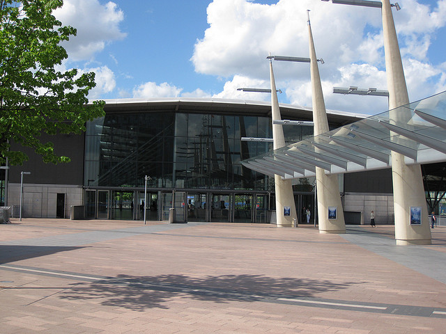North Greenwich bus station. The escalators which lead down to the Underground station can just be seen through the main doors. Photo by David Jones [CC BY 2.0] via this flicker page