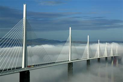 The Millau Viaduct with clouds below its bridge deck. Photo by Peter Stevens [CC BY 2.0] via this flickr page