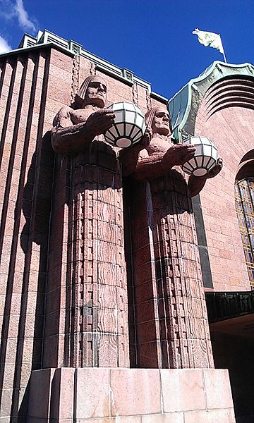 Two of the four statues flanking the main entrance at Helsinki Central. Ethan Doyle White at English Wikipedia [CC BY-SA 3.0], via Wikimedia Commons